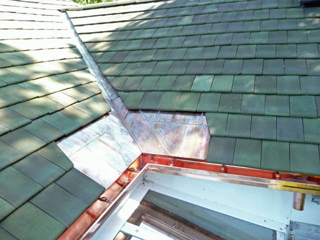 Copper flashing installed in roof valley to prevent ice dam leaks.